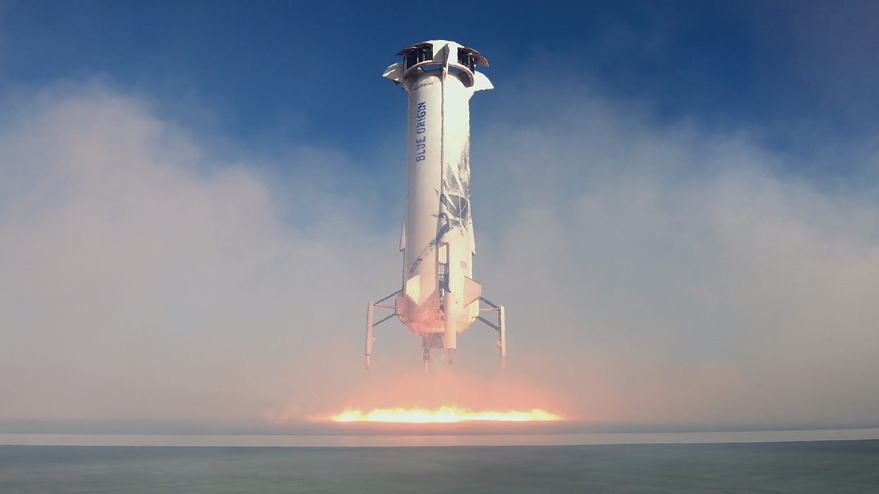 A rather stout rocket takes off, flames below.